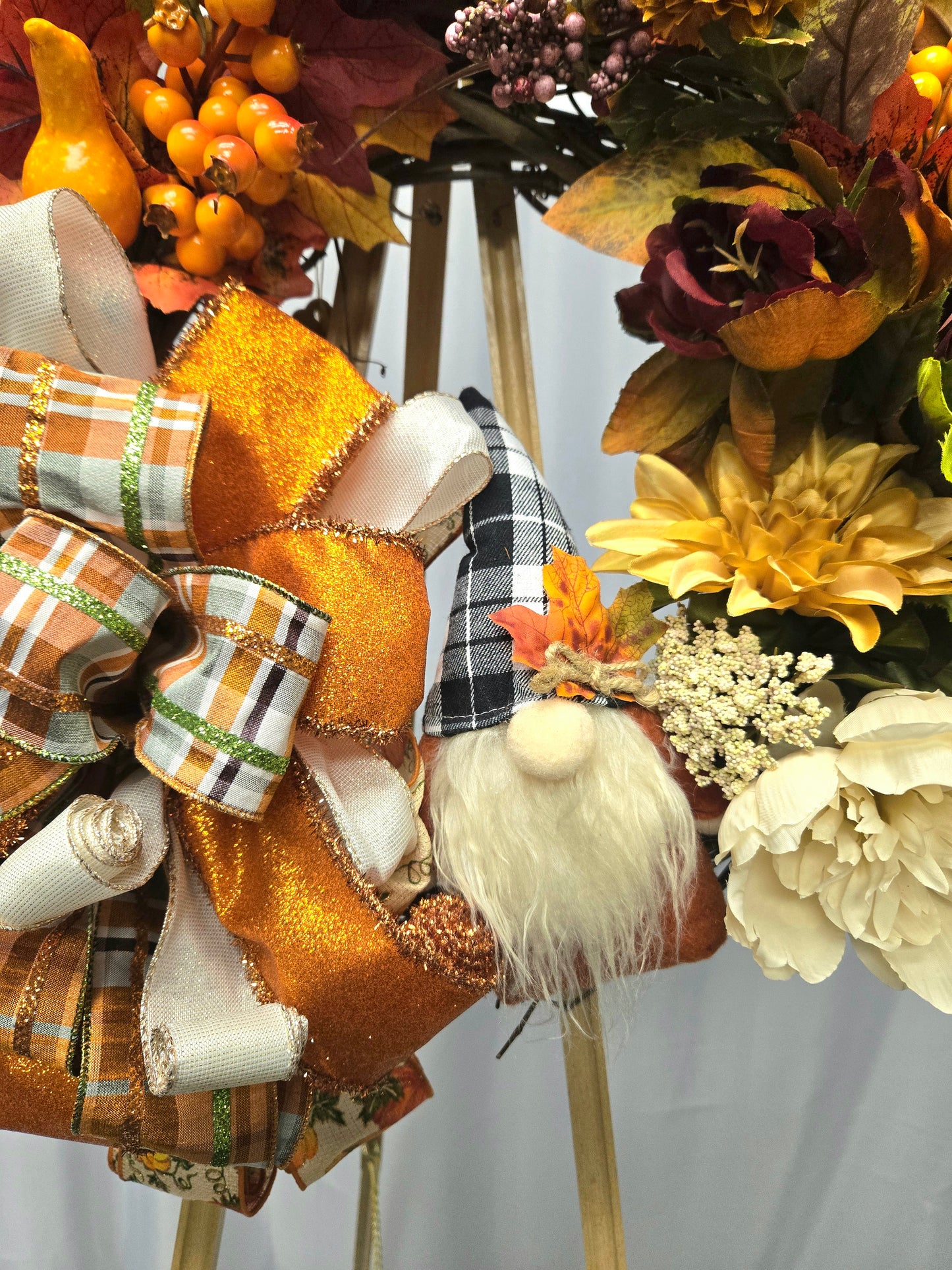 12″ Fall Gnome wreath with orange, brown, beige florals, pumpkin berry picks and large multi-ribbon bow