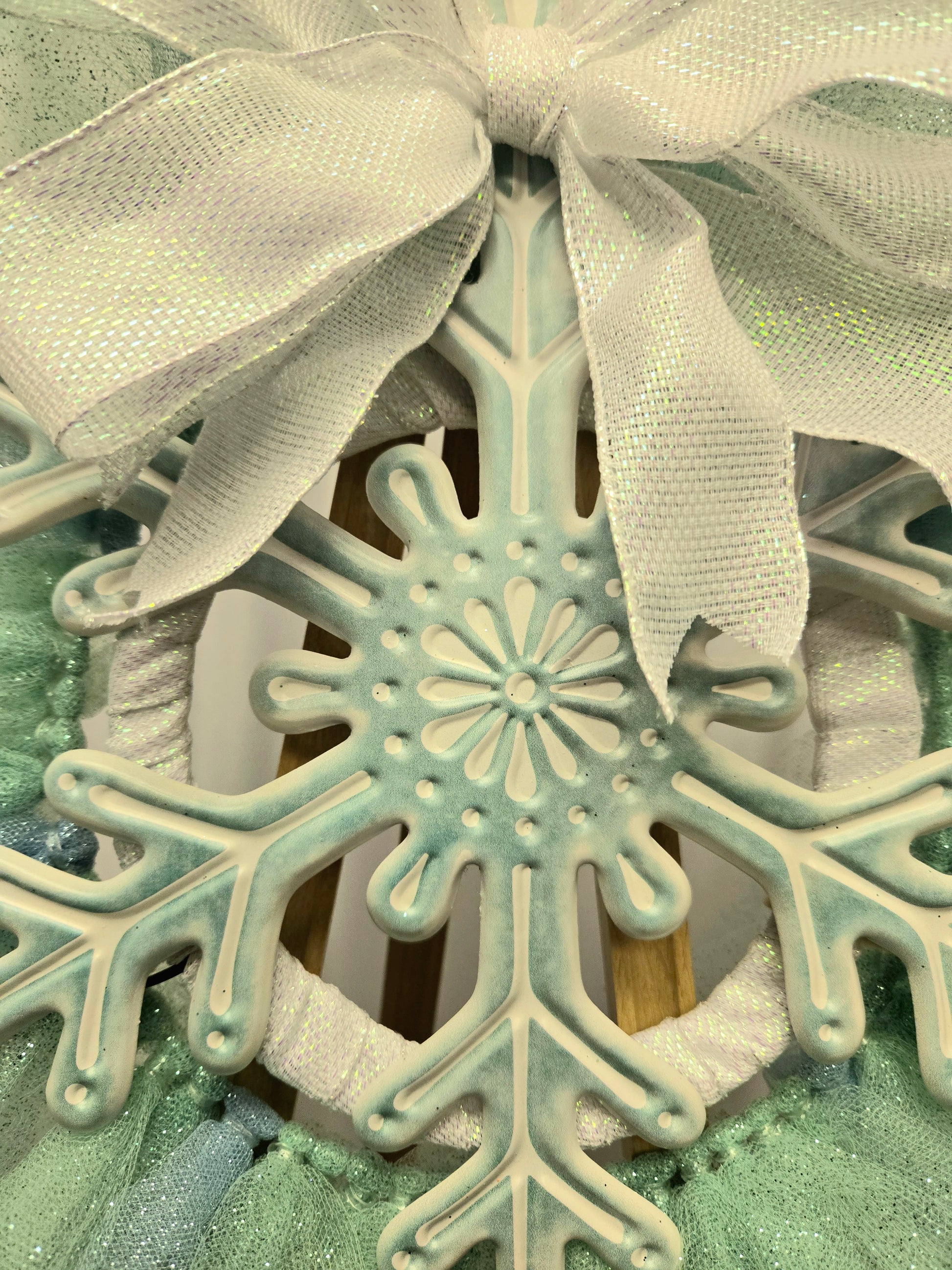 8″ wire wreath with teal and white metal snowflake, pale blue and teal mesh ribbons, and iridescent white bow