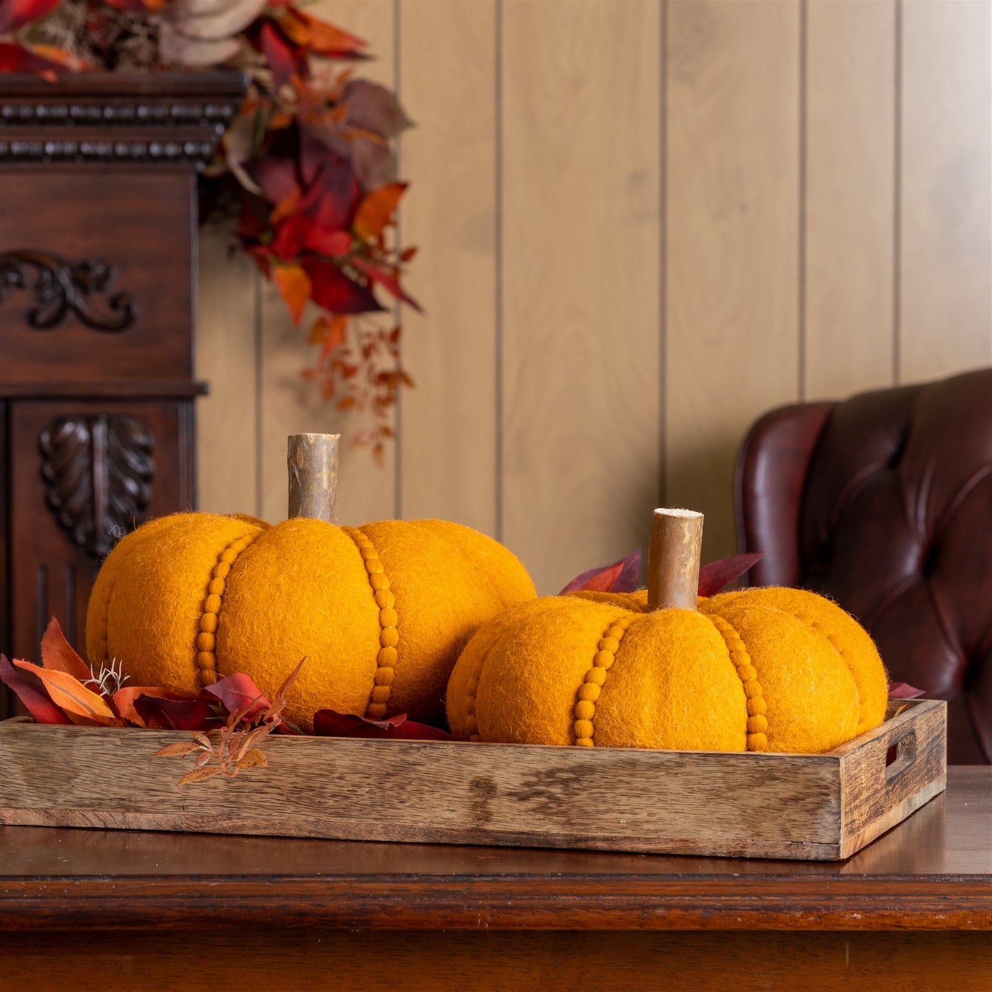 Set of two felt wool pumpkins with orange-brown tones, wooden log stems and beaded accents for rustic fall décor