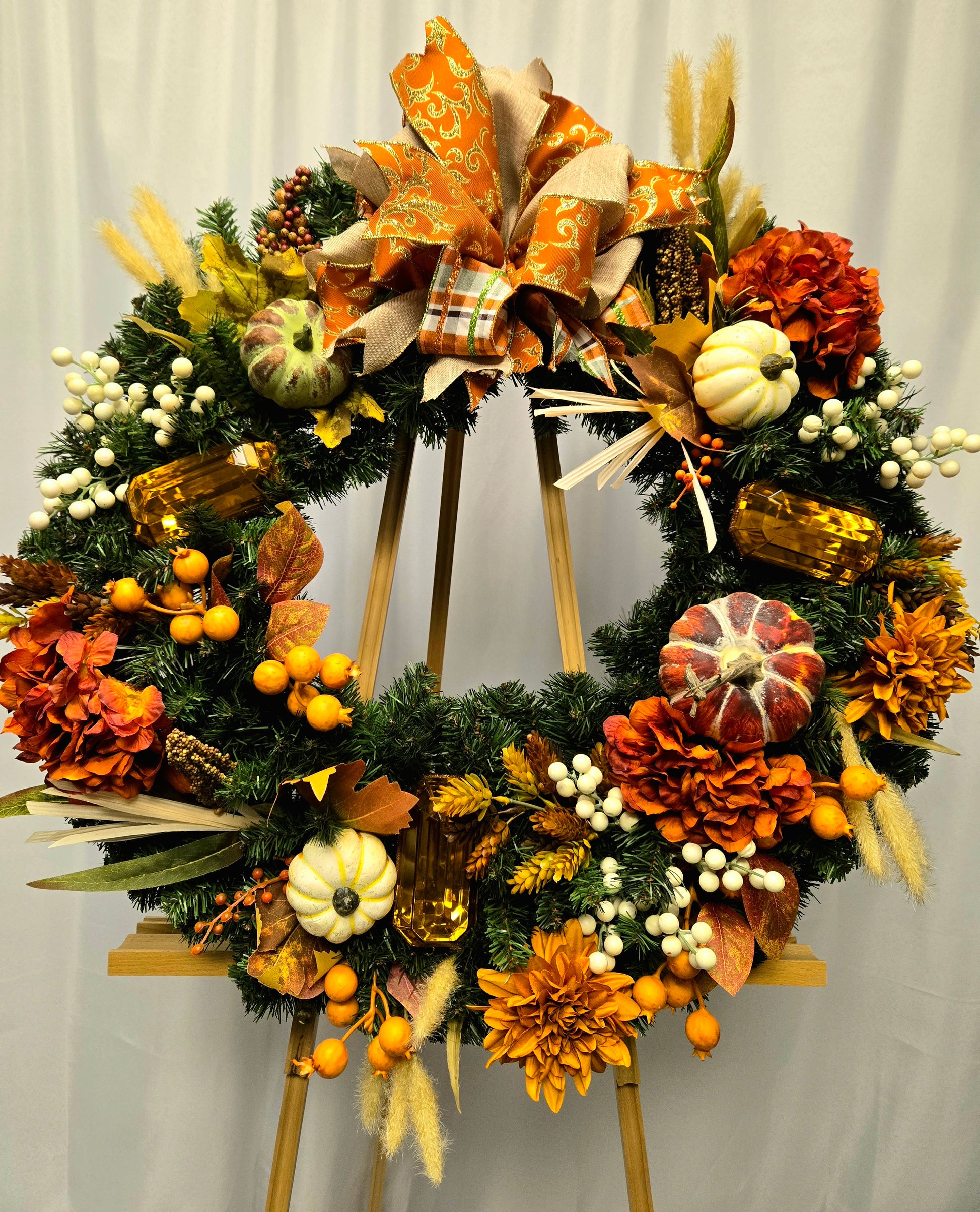 16″ fall wreath with orange, brown, and cream florals, berries, pumpkins, jewels, and coordinating bow

