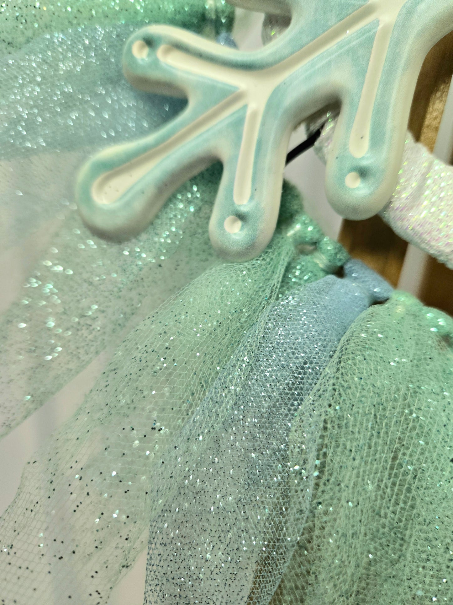 8″ wire wreath with teal and white metal snowflake, pale blue and teal mesh ribbons, and iridescent white bow
