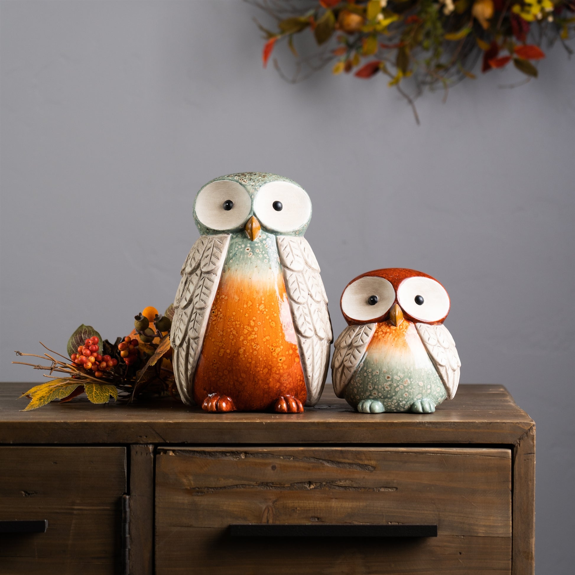 Set of four terra cotta owl figurines with glazed orange, green, and beige accents

