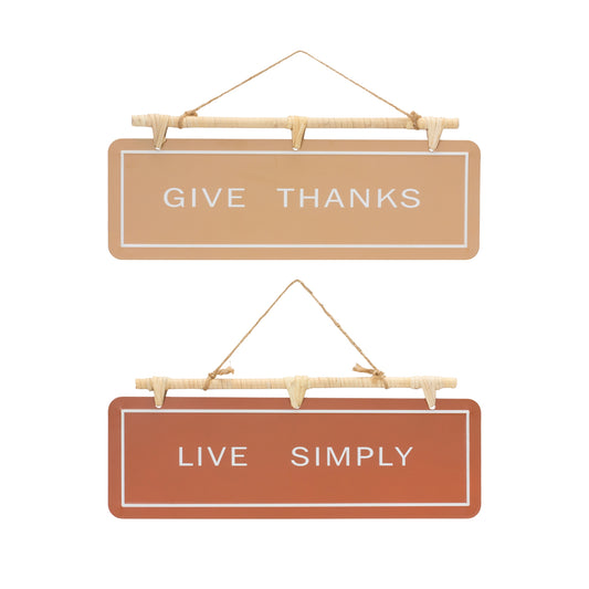 Two hanging fall sentiment signs reading “Give Thanks” and “Live Simply” in warm orange and beige with rattan hanger

