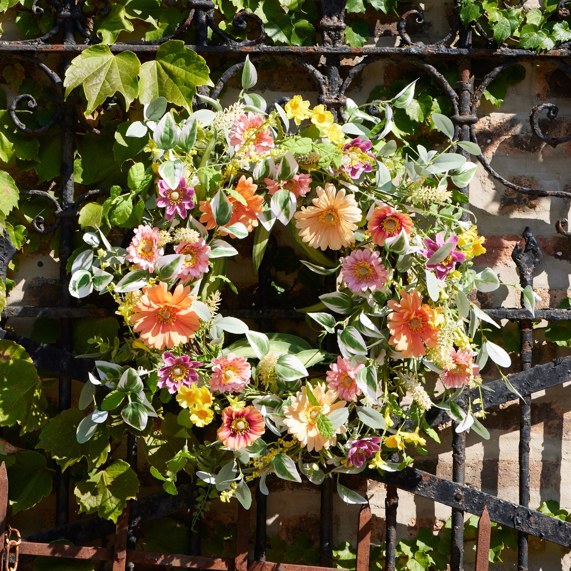 24 inch mixed gerbera daisy wreath with pink & orange blooms, mixed foliage and grapevine base spring accent
